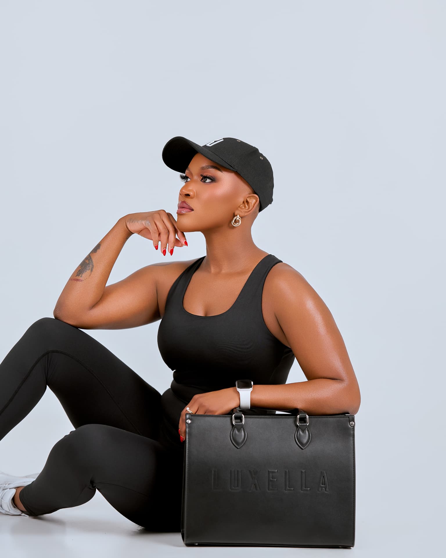Model in signature cap with the embossed Luxella shopper
